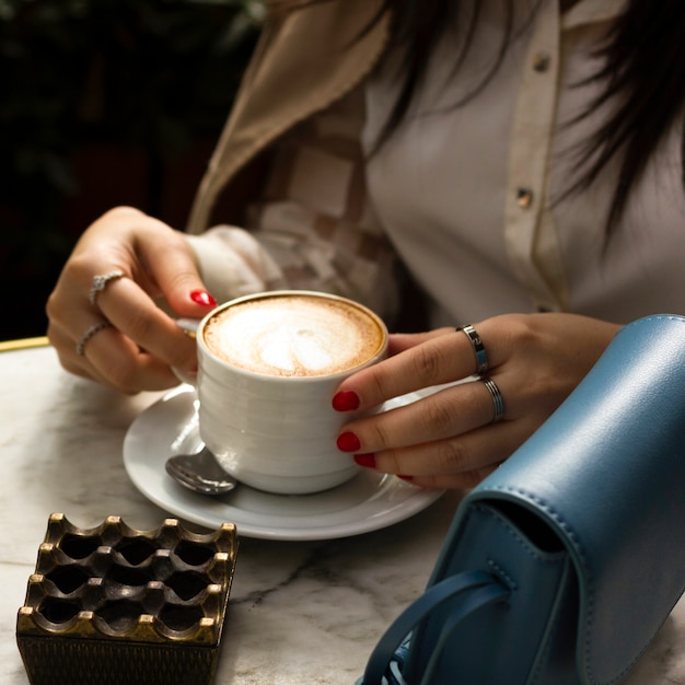 Frau, die Tasse Cappuccino hält