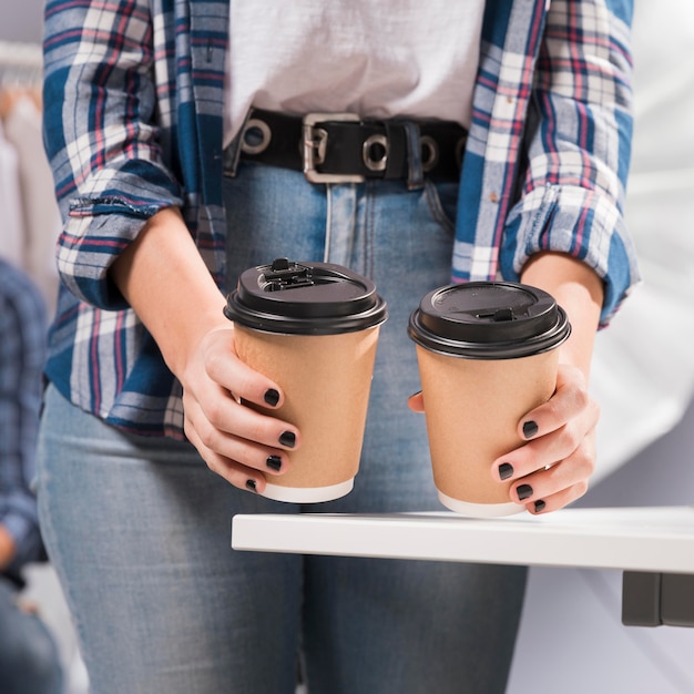 Frau, die Tassen Kaffee im Studio hält