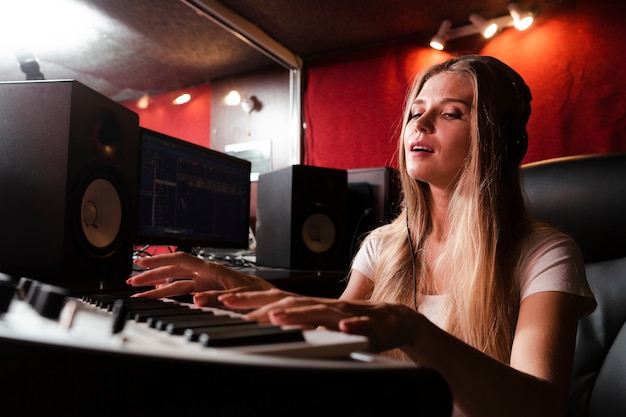 Kostenloses Foto frau, die tastatur spielt und der musik glaubt