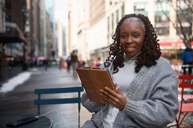 Frau, die Technologie verwendet, während sie in der Stadt unterwegs ist