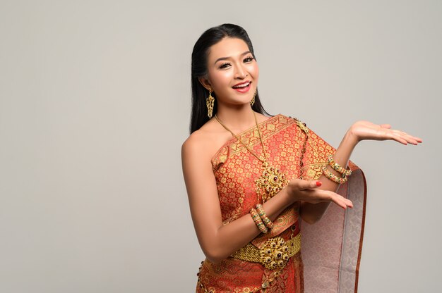 Frau, die thailändisches Kleid trägt, das ein Handsymbol machte