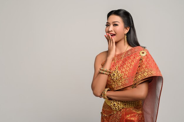 Frau, die thailändisches Kleid trägt, das ein Handsymbol machte