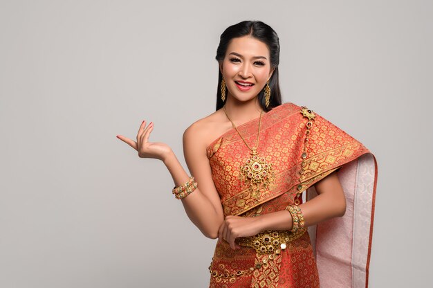 Frau, die thailändisches Kleid trägt, das ein Handsymbol machte