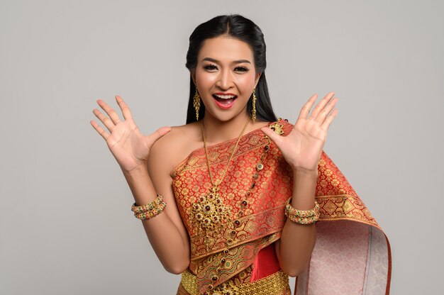 Frau, die thailändisches Kleid trägt, das ein Handsymbol machte