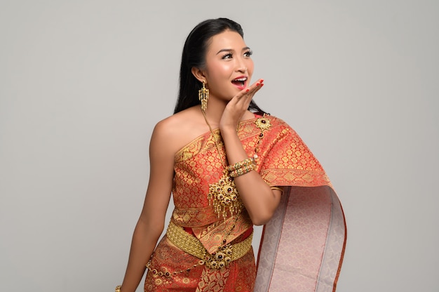 Frau, die thailändisches Kleid trägt, das ein Handsymbol machte