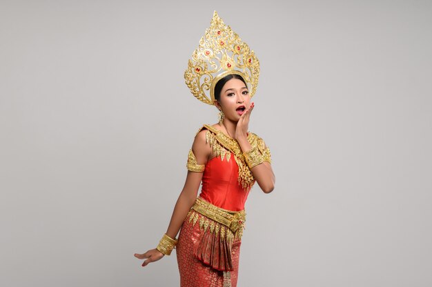 Frau, die thailändisches Kleid trägt, das ein Handsymbol machte