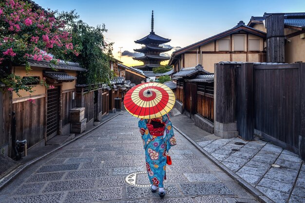 Frau, die traditionellen japanischen Kimono mit Regenschirm an der Yasaka-Pagode und an der Sannen-Zaka-Straße in Kyoto, Japan trägt.