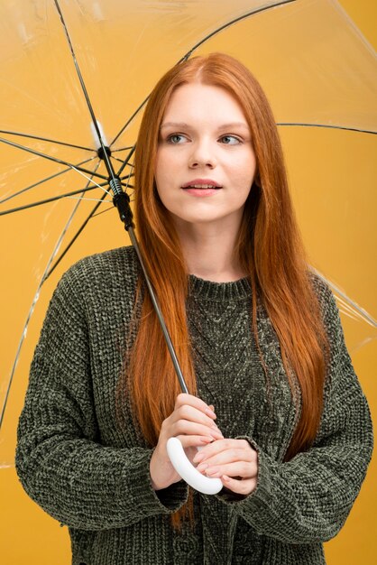 Frau, die transparenten Regenschirm hält