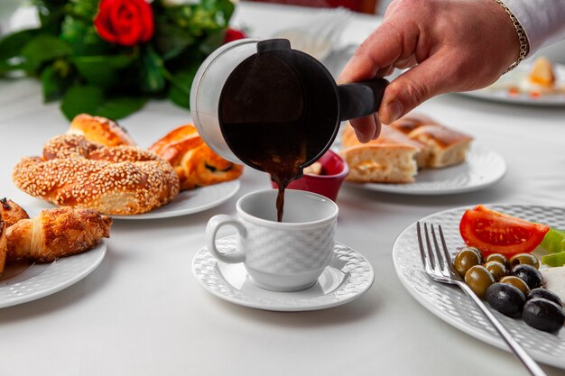 Frau, die türkischen Kaffee in Kaffeetassen-Seitenansicht gießt