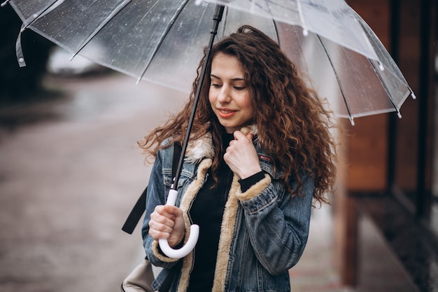Frau, die unter dem Regenschirm in einem regnerischen Wetter geht