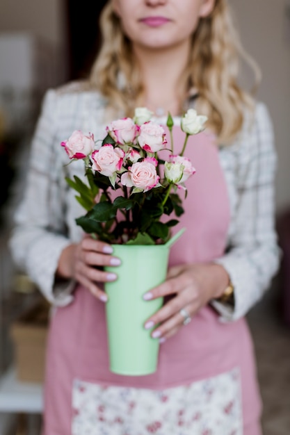 Kostenloses Foto frau, die vase mit rosen hält