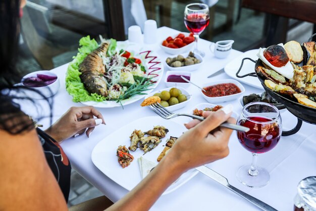 Frau, die verschiedene Lebensmittel beim Sitzen im Restaurant isst