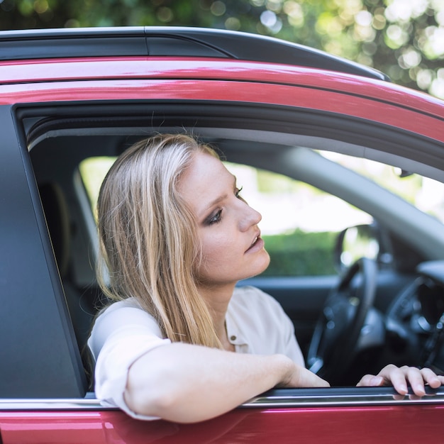 Frau, die vom Autofenster heraus schaut