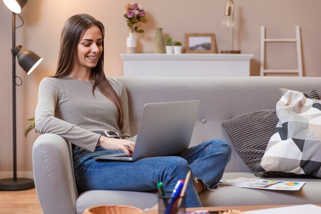 Frau, die von einer bequemen Couch arbeitet