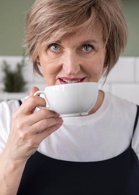 Frau, die von Tasse nah oben trinkt