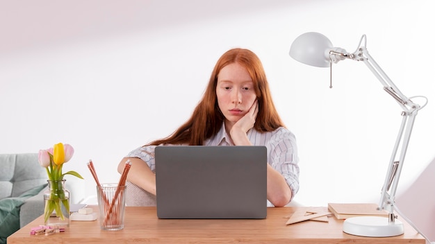 Frau, die von zu Hause auf Laptop arbeitet