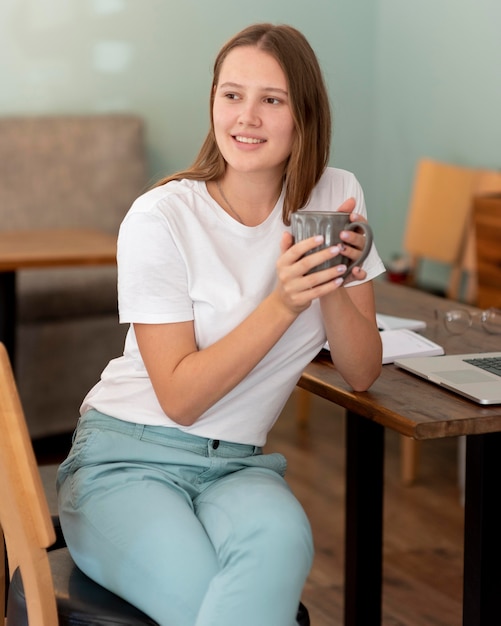 Frau, die von zu Hause während der Pandemie beim Kaffee arbeitet arbeitet