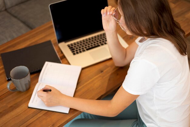 Frau, die von zu Hause während der Pandemie mit Laptop arbeitet