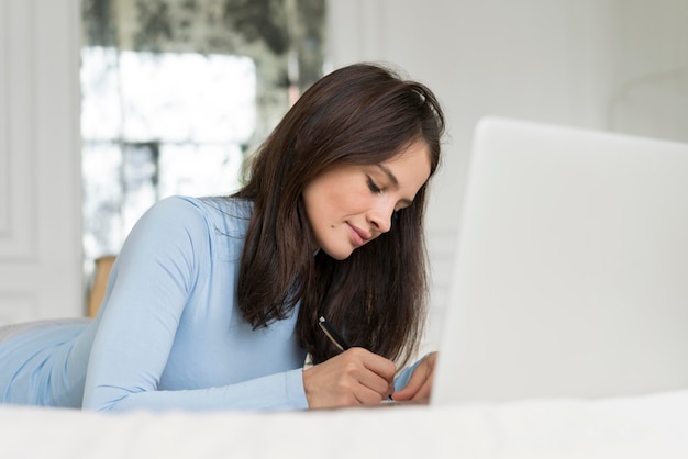 Frau, die während der Arbeit in ihrem Bett bleibt