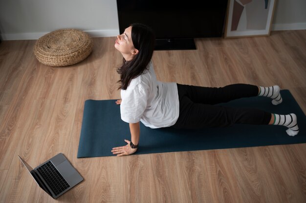 Frau, die während der Quarantäne zu Hause Yoga macht