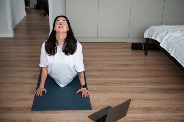 Frau, die während der Quarantäne zu Hause Yoga macht