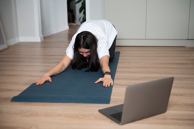 Frau, die während der Quarantäne zu Hause Yoga macht
