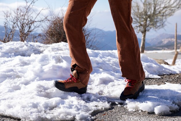 Frau, die während der Reise auf dem Schnee spazieren geht