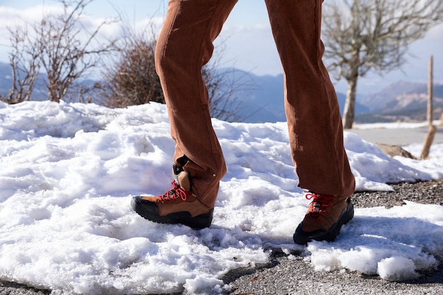 Frau, die während der Reise auf dem Schnee spazieren geht