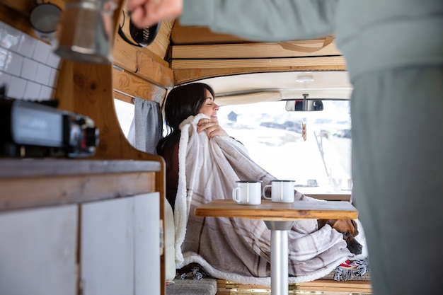 Frau, die während der Winterreise Kaffee für sich und ihren Liebhaber zubereitet