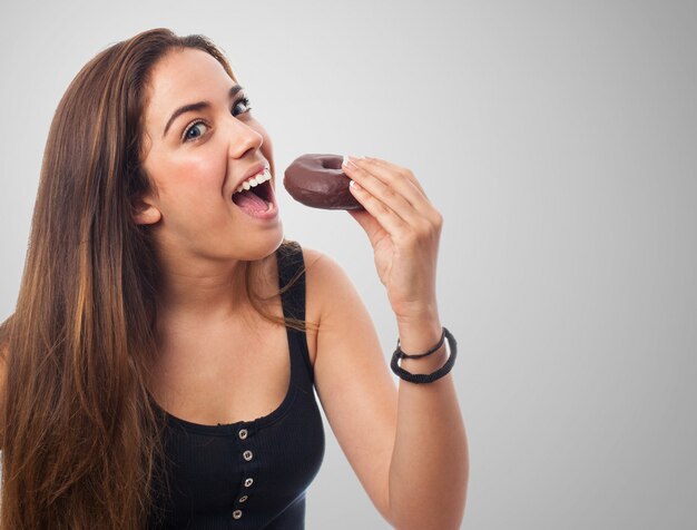 Frau, die wie sie isst einen Donut