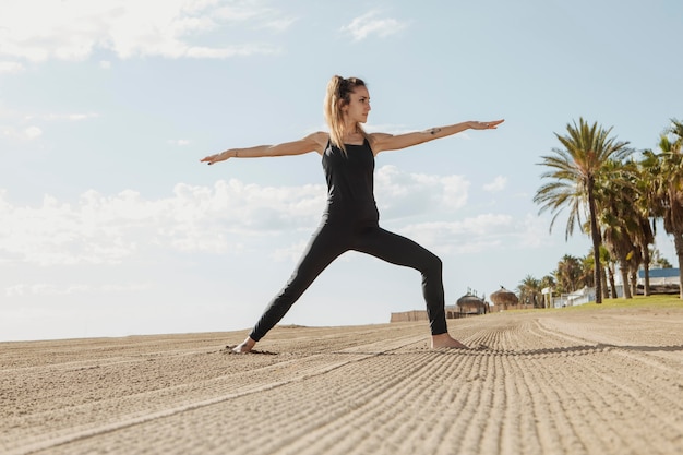 Frau, die Yoga am Strand praktiziert