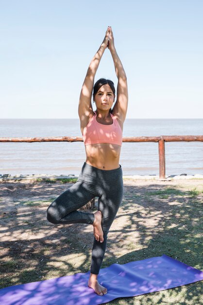 Frau, die Yoga am Strand tut