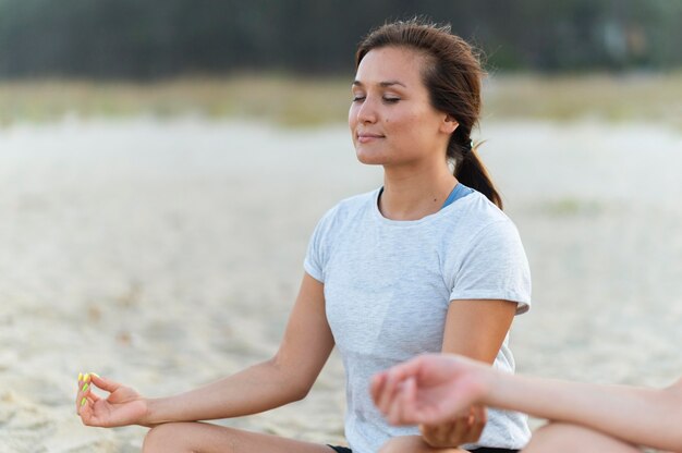 Frau, die Yoga am Strand tut