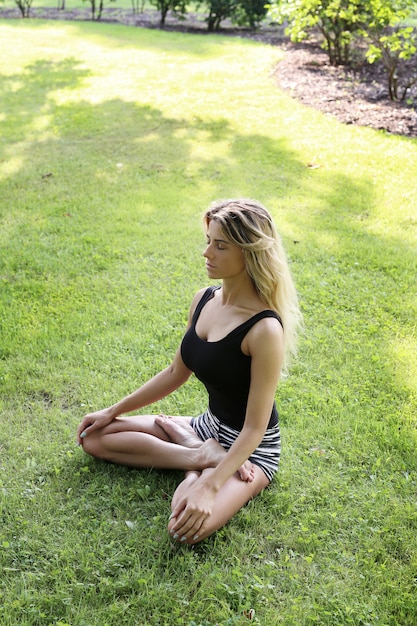 Kostenloses Foto frau, die yoga im freien praktiziert