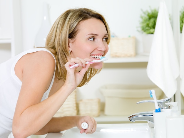 Kostenloses Foto frau, die zähne mit zahnbürste reinigt