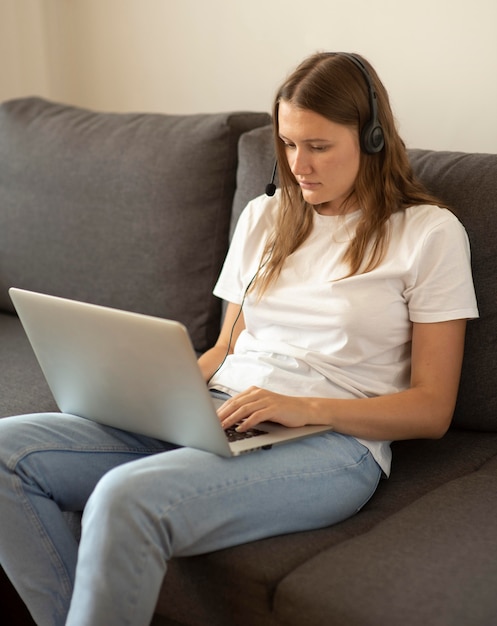 Frau, die zu Hause auf dem Sofa während der Quarantäne arbeitet