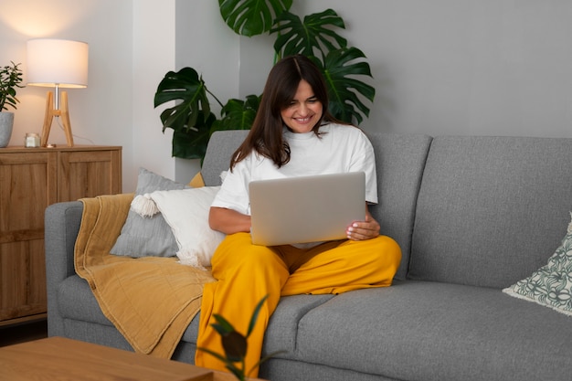 Frau, die zu Hause einen Videoanruf auf einem Laptop-Gerät führt