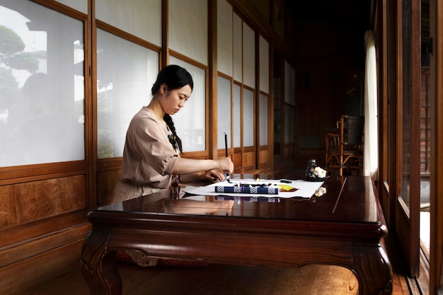 Frau, die zu Hause japanische Handschrift übt