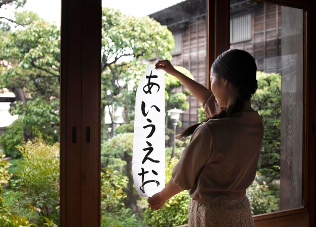 Frau, die zu Hause japanische Handschrift übt