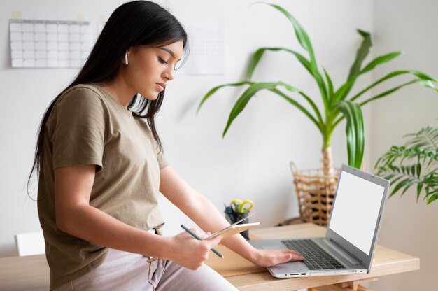 Frau, die zu Hause mit Laptop arbeitet