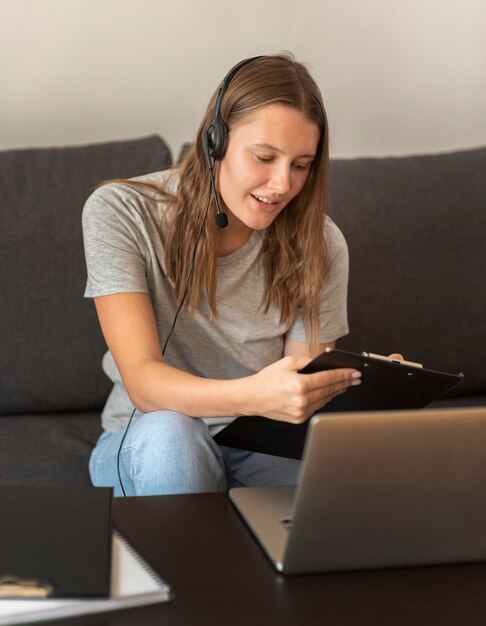 Frau, die zu Hause während der Quarantäne auf Laptop arbeitet