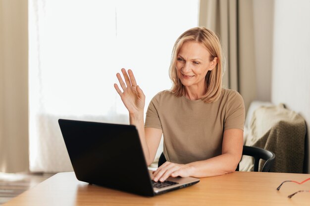 Frau, die zu Hause während der Quarantäne mit Laptop arbeitet