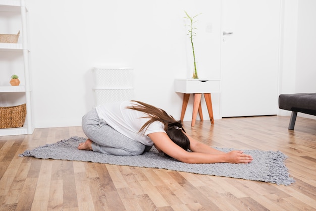 Frau, die zu Hause Yoga tut