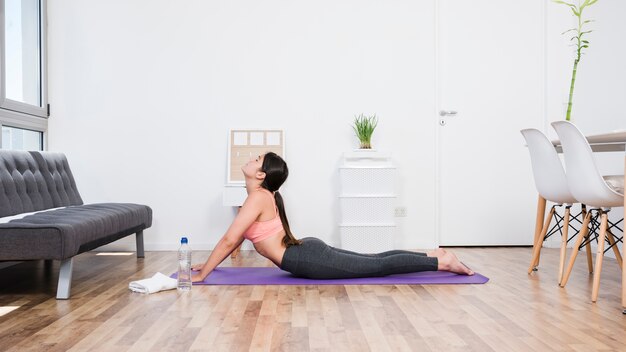 Frau, die zu Hause Yoga tut