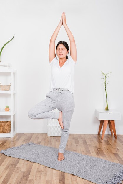 Frau, die zu Hause Yoga tut