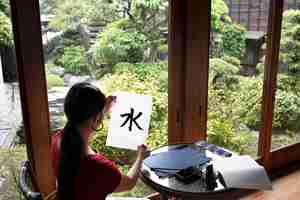Kostenloses Foto frau, die zuhause japanische handschrift übt