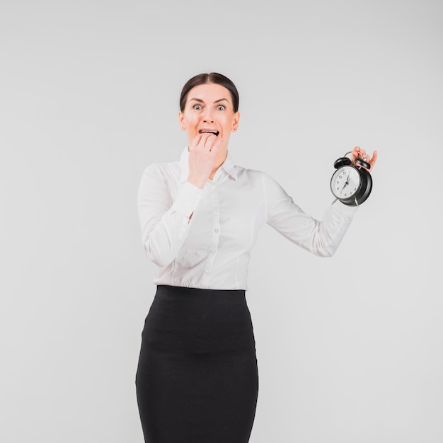 Frau erschrockener Wecker in der Hand