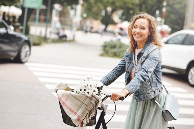 eine frau fährt mit dem fahrrad durch die stadt