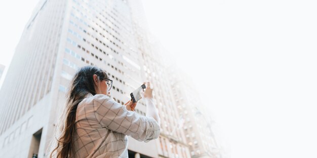 Frau fotografiert den Wolkenkratzer sky