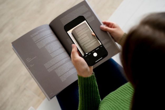 Frau fotografiert eine Zeitschrift mit ihrem Smartphone